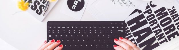 Frau mit roten Fingernägeln schreibt auf Laptop